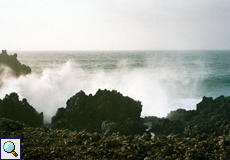 Die Welle bricht sich am Fels